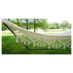 a large white hammock sitting on top of a lush green field