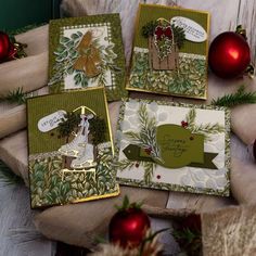 four christmas cards on a table with ornaments