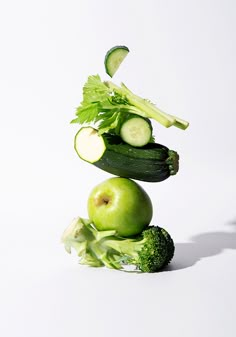 an apple and cucumber stacked on top of each other in the shape of a stack