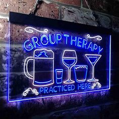 a neon sign that says group therapy and two glasses of wine in front of a brick wall