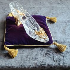 a glass object sitting on top of a velvet pillow