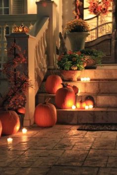 halloween pumpkins lit up on the steps in front of a house