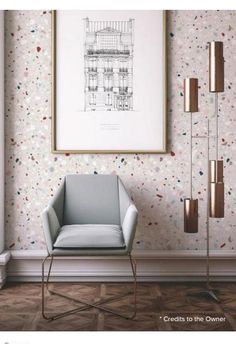 a chair in front of a wall with confetti on it and a framed drawing