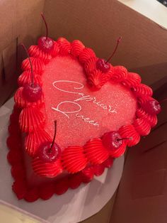 a heart shaped cake in a box with writing on it