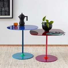 two tables with different colored bases and one has a potted plant on the table