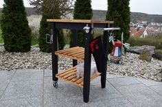 a wooden table with two shelves on top of it and some trees in the background