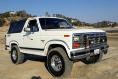 a white truck parked on top of a sandy beach