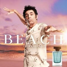 a man standing on top of a sandy beach next to a bottle of perfume in front of the ocean