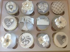 twelve cupcakes decorated with white and grey decorations