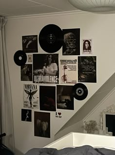 a bedroom with white walls and black vinyl records on the wall