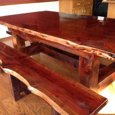 a large wooden table with two benches in front of it on a hard wood floor