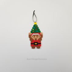 a christmas ornament hanging on a wall with a santa clause hat and beard