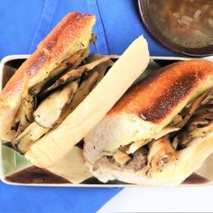 two sandwiches are on a plate next to a bowl of soup