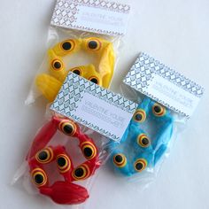 three different colored plastic eyeballs sitting on top of each other's packaging bags