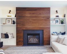 a living room with a fire place in the center and shelves on either side of the fireplace