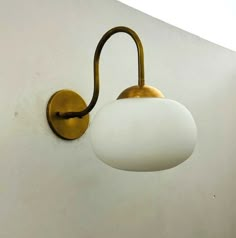 a light that is on the wall next to a white wall with a black handle