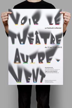 a man holding up a poster with the words voir de theatre autre in it