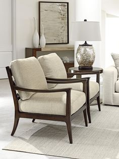 a living room filled with furniture and a lamp on top of a wooden table in front of a white couch