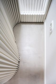 the interior of a modern building with white walls and vertical slats on the ceiling