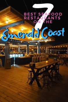 an outdoor restaurant with wooden tables and chairs under the awning at night, with text overlay that reads 7 best seafood restaurants on the emerald coast