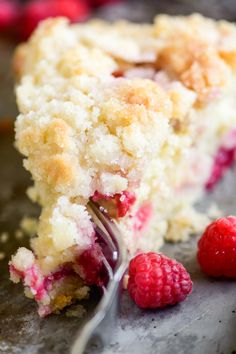 a piece of cake with raspberries and a fork