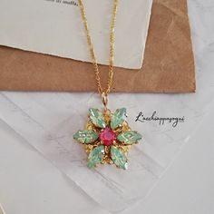 "Anastasia Together In Paris Necklace Miniature Version - ENGRAVED Swarovski Chrysolite Opal and Royal Red EXCLUSIVE DESIGN BY L'ACCHIAPPASOGNI JEWELRY since 2017 © L'Acchiappasogni Jewelry (Chrysolite first published Oct. 16, 2019) This Anastasia Together in Paris Necklace is the ideal gift for a fan of the movie or for Anastasia Romanov cosplay. It features 14k gold plated stainless steel & 14k gold plated brass components andSwarovski elements: CHRYSOLITE Green navettes and a Royal Red rh Together In Paris, Paris Necklace, Anastasia Romanov, Royal Red, Red Rhinestone, Gold Filled Jewelry, Crystal Necklace, Gold Chains, Ideal Gift