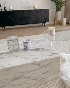 a white marble coffee table with candles on it