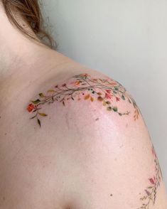 a woman's shoulder with flowers painted on it