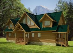 a log home with green roofing in the woods near trees and mountains on a sunny day