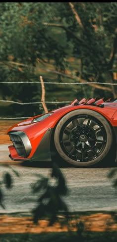 an orange sports car driving down the road