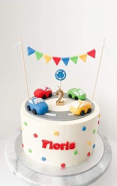 a birthday cake decorated with cars and flags