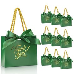 six green gift bags with gold lettering on them and a bow tied around the handles