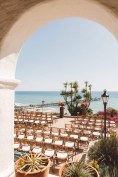 an outdoor ceremony set up with chairs overlooking the ocean