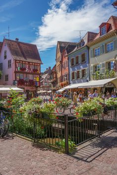 an old town with many colorful buildings and flowers in the foreground, on a sunny day