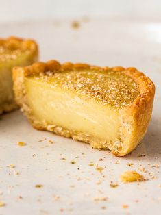 two pieces of pie sitting on top of a white plate covered in powdered sugar