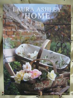 a book with flowers sitting on top of a chair in front of a brick wall