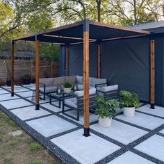 a covered patio with seating and potted plants