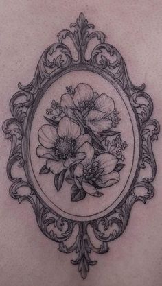 the back of a woman's stomach with flowers in a frame on it,