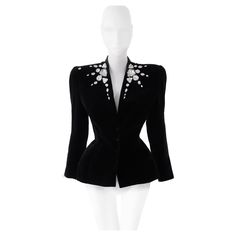 The most amazing glamorous Thierry Mugler jacket. FW1985/86 Collection, Museum worthy collectors piece. Unworn condition with original tag. Black high quality velvet with amazing big rhinestone crystal details. Strong shoulders and sculptural shape with fitted waist and super feminine silhouette. Deep V-neck, closes with press buttons on the front. Thierry Mugler Made in France Marked Vintage Size 40 Deadstock with original Tag! please note that any pictures of documentation like runway shows ar Vintage Mugler Jacket, Mugler Jacket, 1970s Glam, Versace Couture, Strong Shoulders, Black Tweed, Evening Jackets, Thierry Mugler, Feminine Silhouette