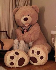 a large teddy bear sitting on top of a wooden floor