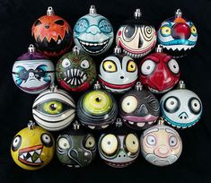 a bunch of different colored glass ornaments on a black background, with eyes and mouths painted on them