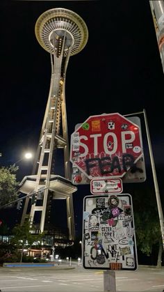 a stop sign with stickers on it next to a tall tower