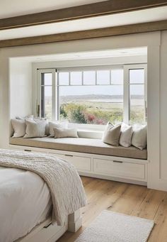 a bedroom with a large window seat next to a bed