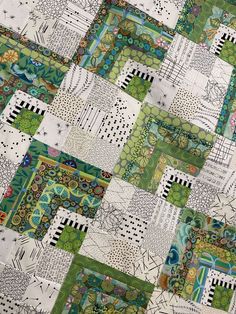 a patchwork quilt with green and white designs on it's sides, all in different colors