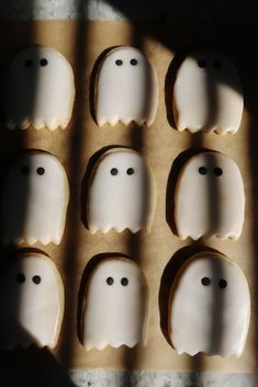 eight decorated cookies in the shape of ghost faces