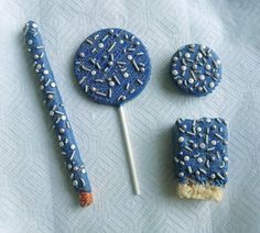 blue and white cake pops with sprinkles on them, next to a toothbrush