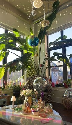 a living room filled with lots of plants and decorations on top of a white table