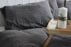 a table with a bottle on top of it next to some pillows and a pillow