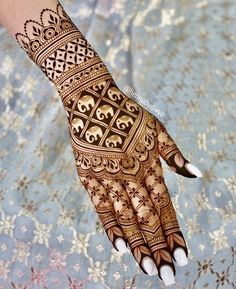 a woman's hand with henna tattoos on it