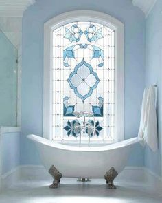 a bath tub sitting next to a window in a bathroom